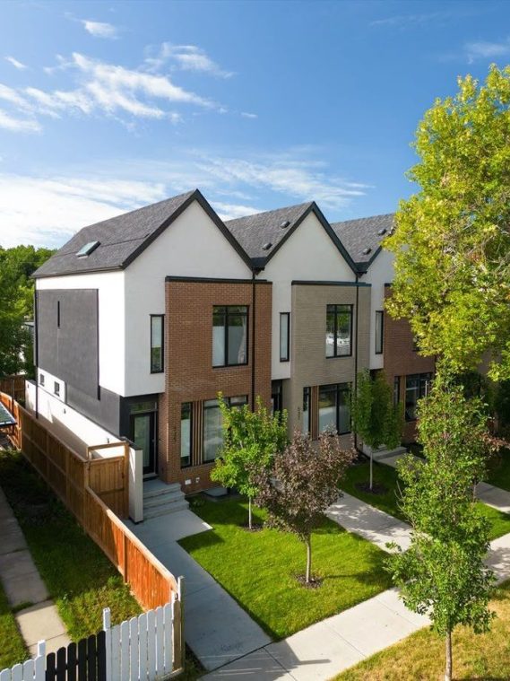 A modern home surrounded by a fence and trees, showcasing contemporary architecture and landscaping.